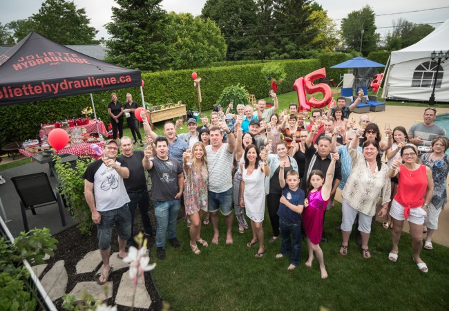 Groupe de personnes célébrant un 15e anniversaire dans un jardin avec piscine, ballons rouges et tente Joliette Hydraulique.
